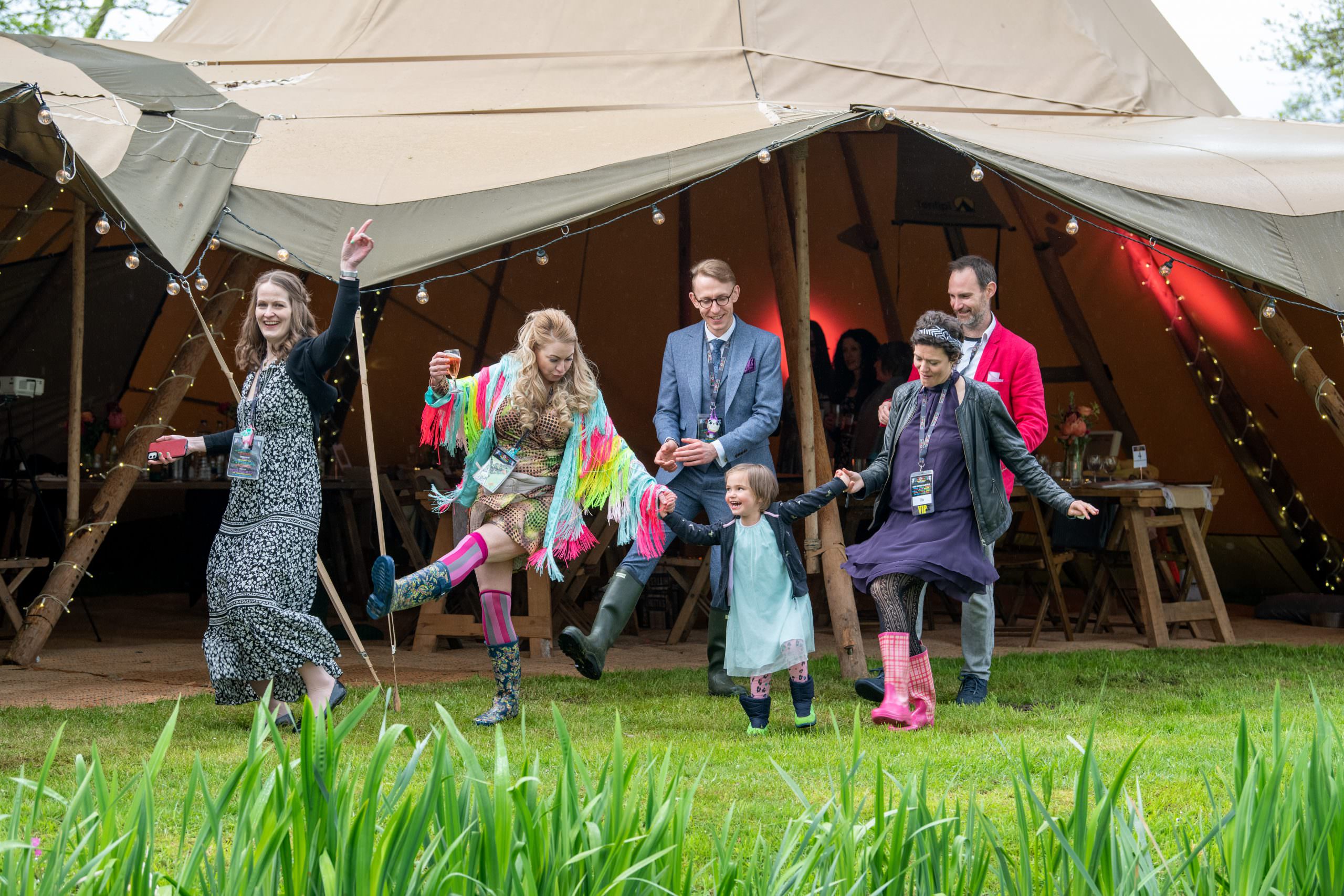 Wedding guests dancing outide event tipi in Ludham Norfolk